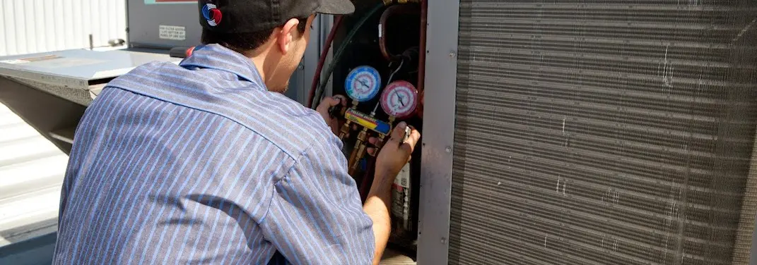 HVAC technician servicing a condenser unit in Colebrookdale
