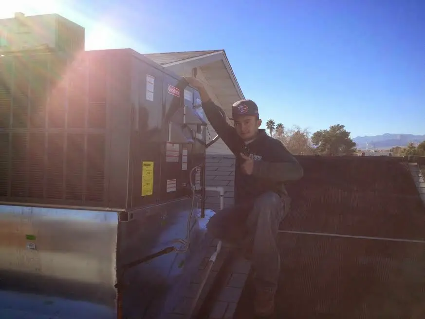 HVAC technician performing AC Tune-Up on a rooftop unit in Colebrookdale